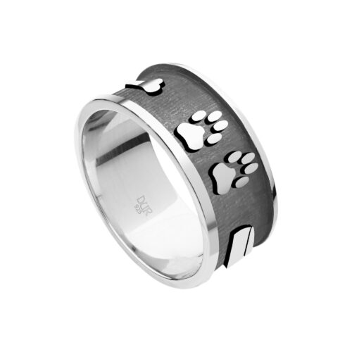 Ring „Lucky Dog“ aus 925er Sterling-Silber, ausdrucksstark gestaltet mit einer Breite von ca. 9 mm. Die Kombination aus glänzenden Silbermotiven und dunklem Hintergrund verleiht dem Ring eine moderne, kontrastreiche Optik. Mehrere detailreich ausgearbeitete Symbole – darunter zwei Hundepfoten, ein Napf und ein Knochen – prägen das Design und machen den Ring zu einem besonderen Schmuckstück für Hundeliebhaber. Die Motive heben sich plastisch vom dunklen Untergrund ab und rücken so die emotionale Verbindung zum Tier in den Mittelpunkt. Die Innenseite ist glatt gearbeitet und sorgt für ein angenehmes Tragegefühl im Alltag. Durch die hochwertige Verarbeitung entsteht ein langlebiges Schmuckstück, das sich vielseitig kombinieren lässt und die Liebe zum Hund stilvoll zum Ausdruck bringt.
